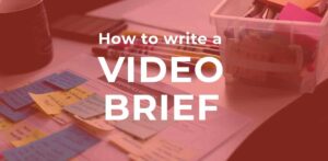image of pens, paper and post its with text "how to write a video brief" overlaid by Vermillion Films Video Production Company Birmingham