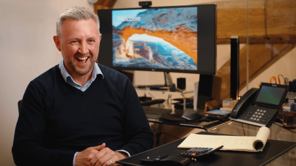 Paul Cleworth at Tandem Financial laughing behind his desk by Vermillion Films Video Production Company in Birmingham