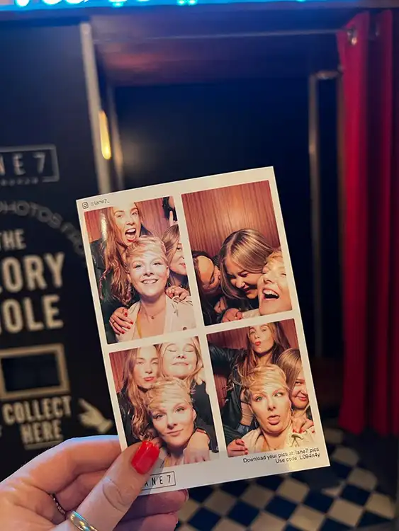 A set of 4 photos taken in a photo booth on a team night out. The photos contain 3 women laughing together and having a great time.