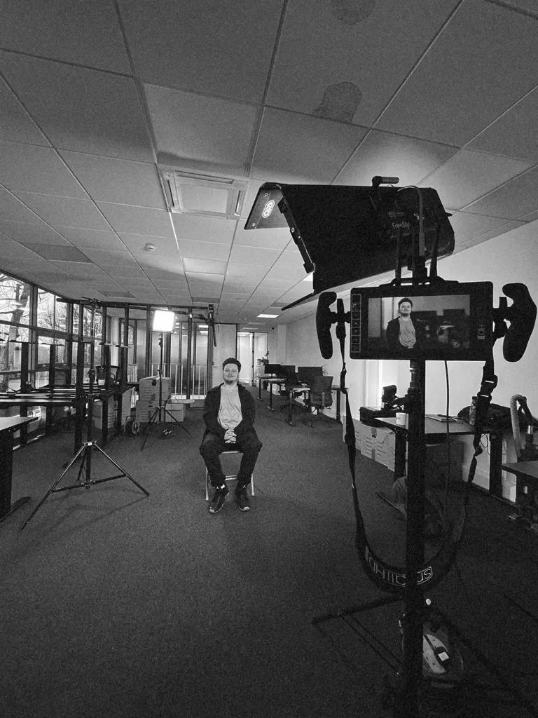 Corporate Video for startup image features a young man standing in for an interviewee. There are professional lights in shot.